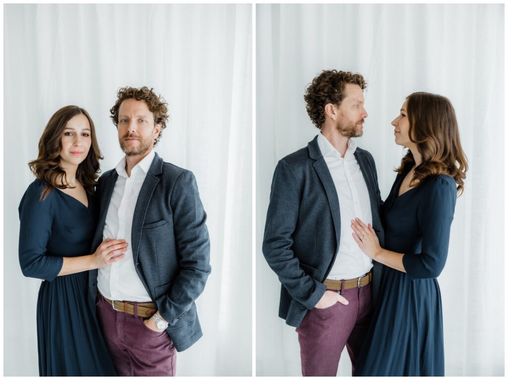 Couple embracing in soft natural light during a modern engagement session in a South Bend studio. Couple is wearing a combination of Navy and maroon, with Zach in a white shirt and Navy jacket.