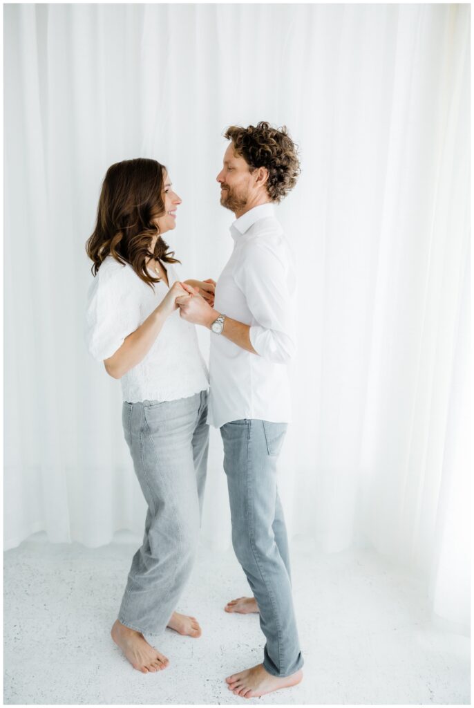 Dana and Zach standing together in a bright, minimal studio during their winter engagement session in South Bend.