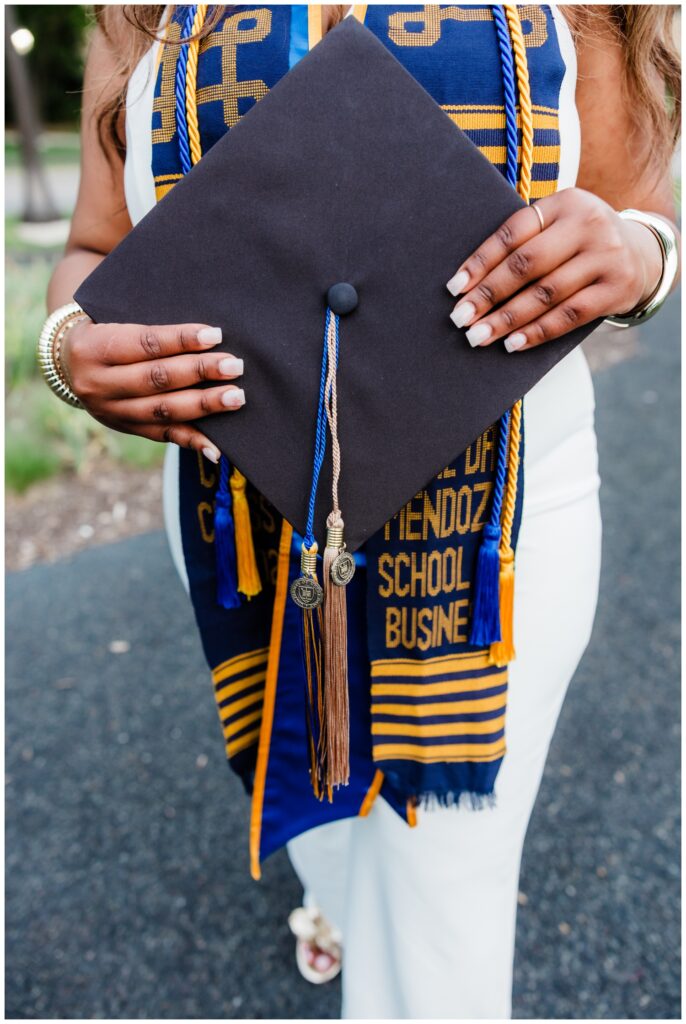 Graduate holding cap in hands photographed by Leah Rife Photo on the University of Notre Dame campus.
