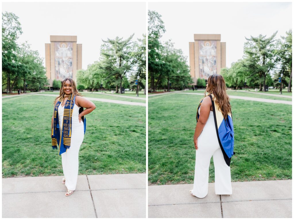 Njeri standing in front of the library at the University of Notre Dame campus in soft evening light after earning her master’s degree.